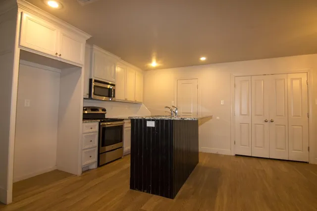 a kitchen with stainless steel appliances a refrigerator and a stove top oven