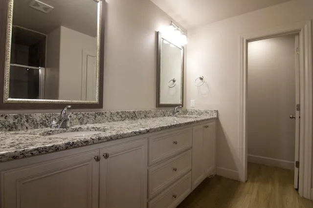 a bathroom with a granite countertop sink and a mirror