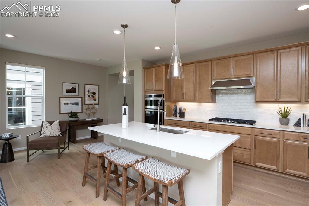 631 Felicity Loop Castle Rock, CO 80109 - Photo 7 of 33 a kitchen with a dining table chairs cabinets and stainless steel appliances