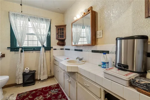 a bathroom with a sink a toilet and mirror