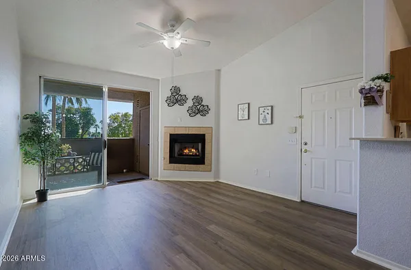 a view of a livingroom with a fireplace wooden floor and windows