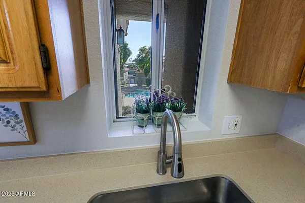 a view of a kitchen with a sink cabinet a microwave and a refrigerator