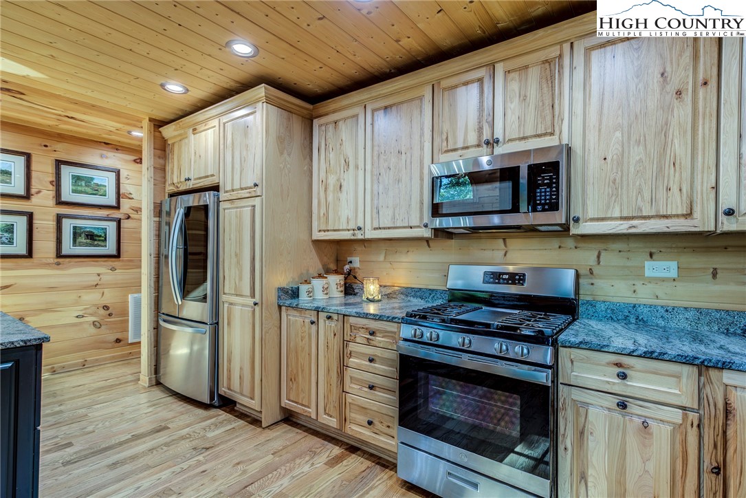 3460 South Center Church Road Thurmond, NC 28683 - Photo 22 of 50 a kitchen with stainless steel appliances granite countertop a stove a refrigerator and a microwave