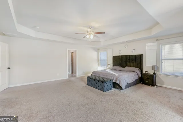 a spacious bedroom with a bed and a ceiling fan