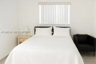 a bedroom with a bed and chair