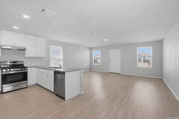 a kitchen with granite countertop a stove and a wooden floors