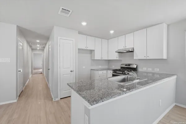 a kitchen with sink refrigerator and cabinets