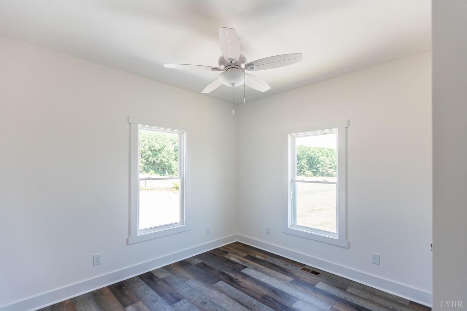 9740 Oakville Road Gladstone, VA 24553 - Photo 49 of 75 an empty room with wooden floor fan and windows