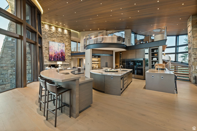 8544 North Promontory Ranch Road Park City, UT 84098 - Photo 5 of 36 Kitchen featuring a breakfast bar, light wood-type flooring, light stone countertops, a high wood ceiling, and modern cabinets