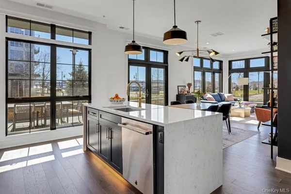 a kitchen with stainless steel appliances granite countertop a stove and white cabinets next to a large window