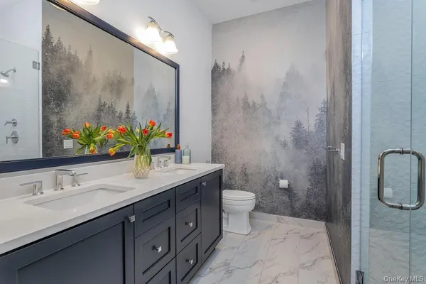 a bathroom with a double vanity sink toilet and a mirror