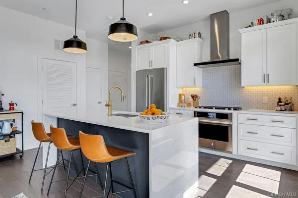a kitchen with stainless steel appliances granite countertop a stove a sink and a refrigerator