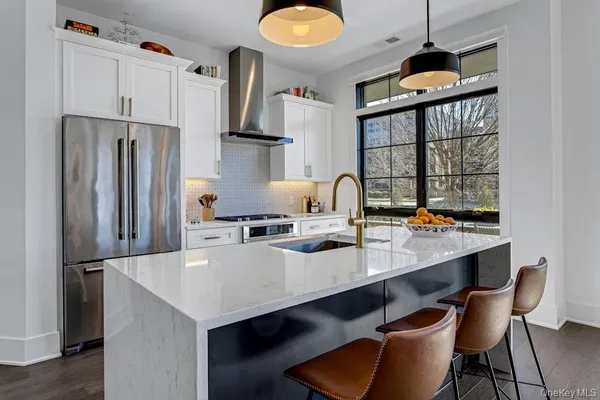 a kitchen with refrigerator and chairs
