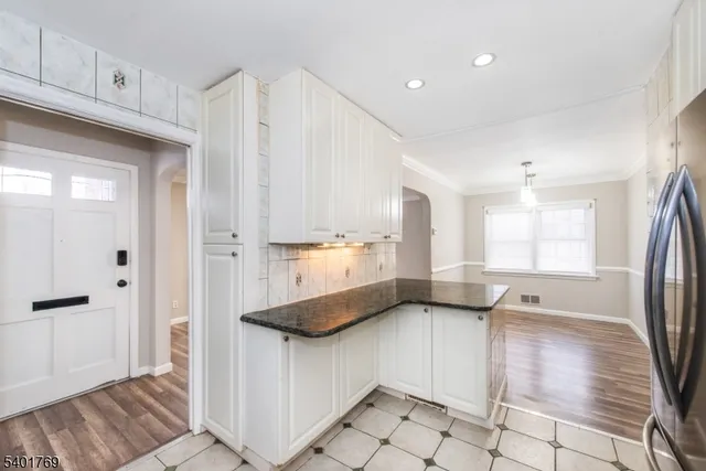 a kitchen with stainless steel appliances granite countertop a refrigerator and a sink