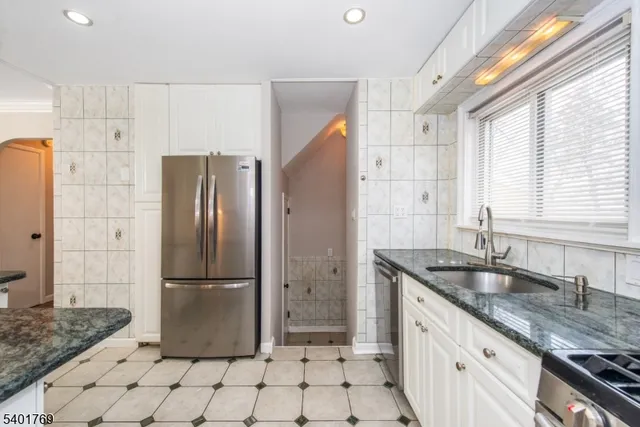 a kitchen with a sink a refrigerator and cabinets