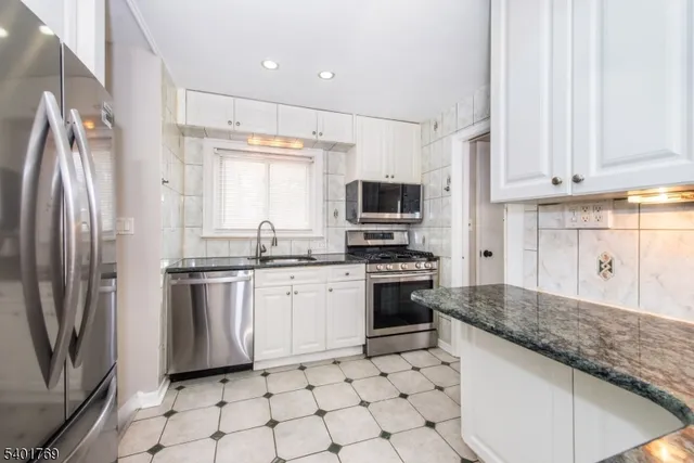 a kitchen with stainless steel appliances granite countertop a refrigerator sink and stove