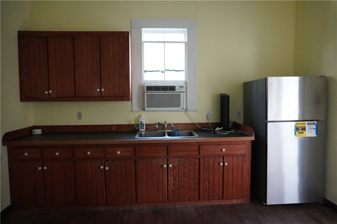 608 West 27th Street Bryan, TX 77803 - Photo 19 of 39 Kitchen with freestanding refrigerator, a sink, dark countertops, cooling unit, and dark wood-type flooring