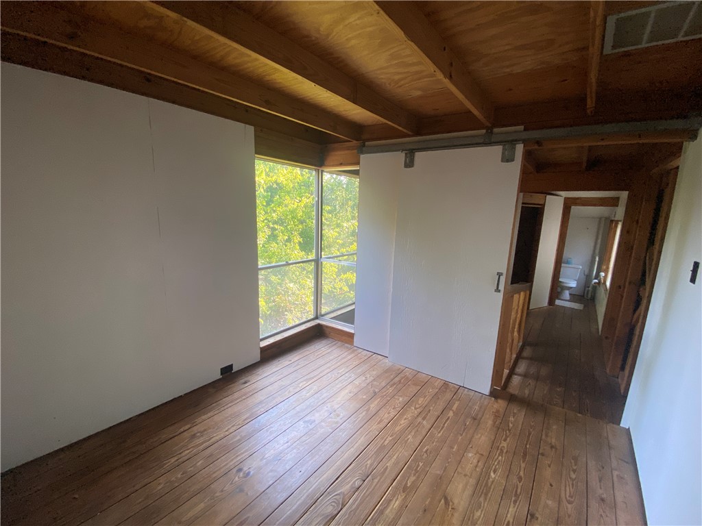 608 West 27th Street Bryan, TX 77803 - Photo 36 of 39 Unfurnished room featuring wood-type flooring and beam ceiling