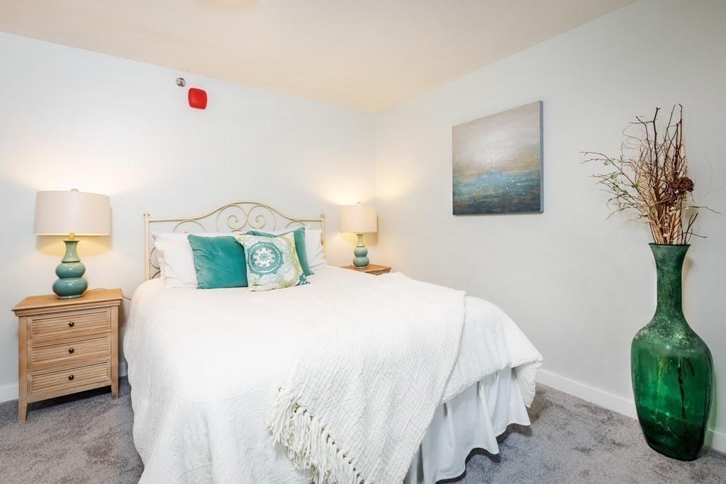 449 Ocean Boulevard, Unit 210 Hampton, NH 03842 - Photo 7 of 13 a bedroom with a bed and a potted plant