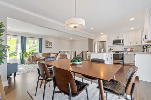 a large white kitchen with lots of counter space and stainless steel appliances