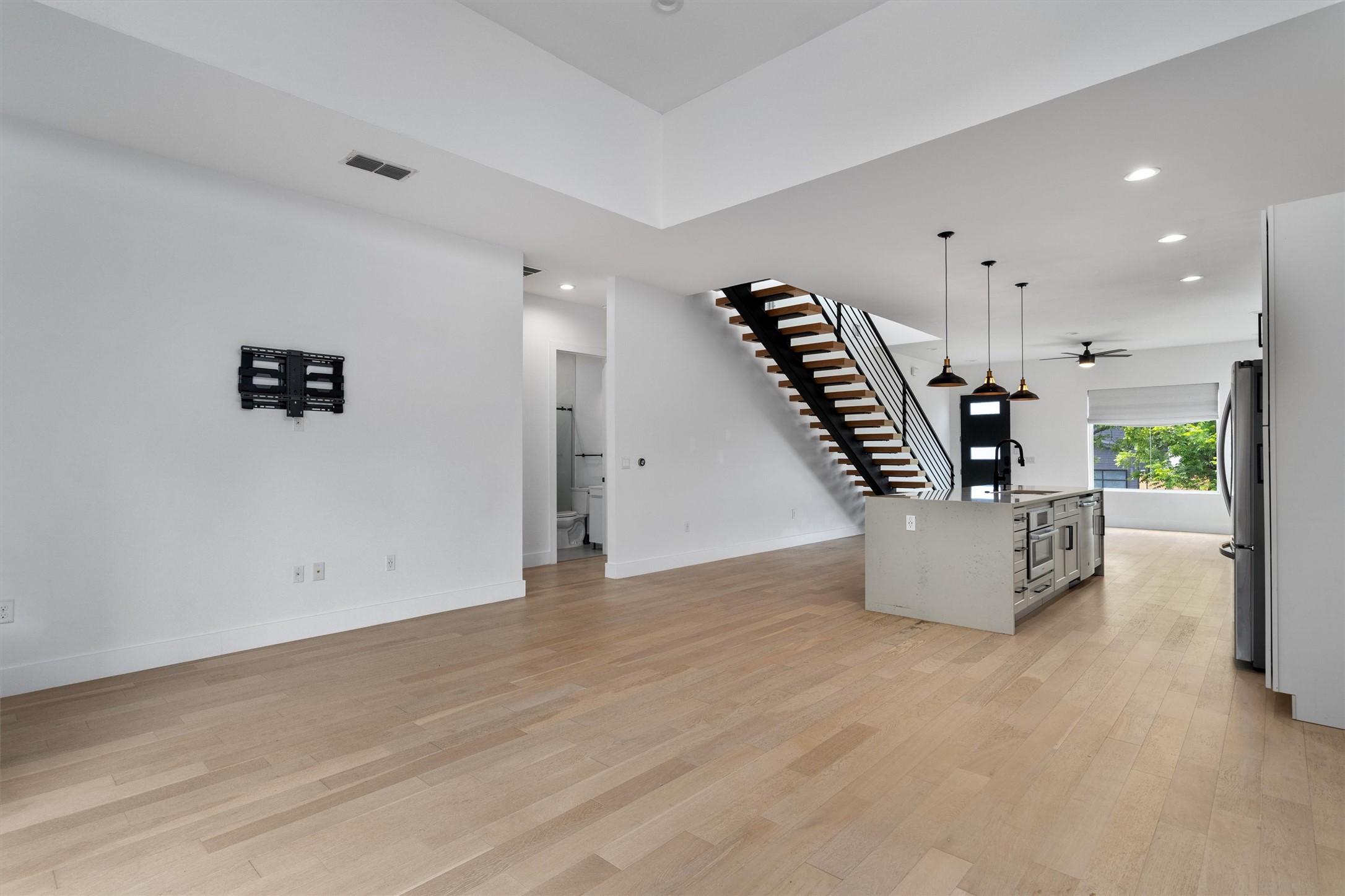 4712 Reyes Street, Unit 1 Austin, TX 78721 - Photo 7 of 38 an empty room with wooden floor and windows