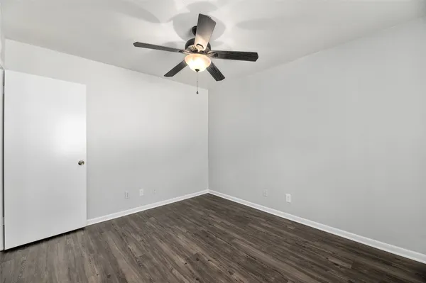 a view of a room with wooden floor and ceiling fan