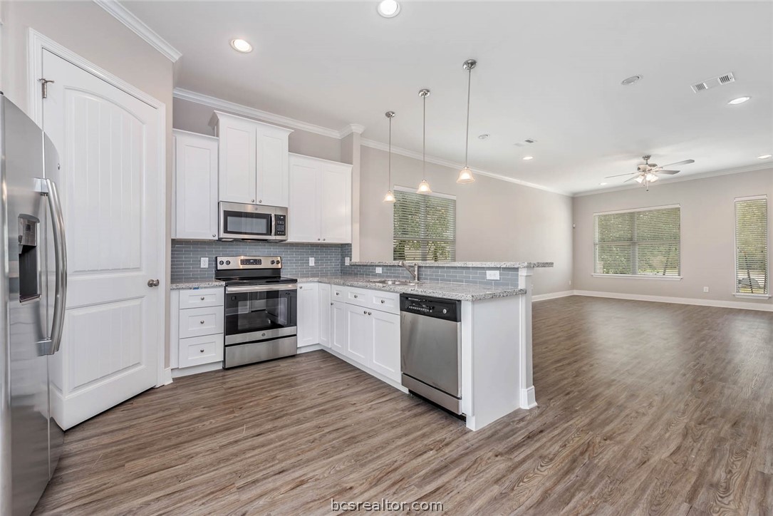 a kitchen with stainless steel appliances white cabinets a refrigerator a stove a sink and a oven