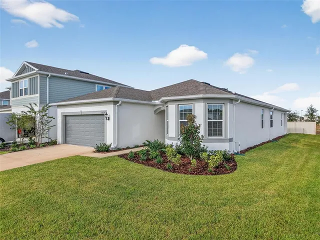 a front view of a house with a garden and yard