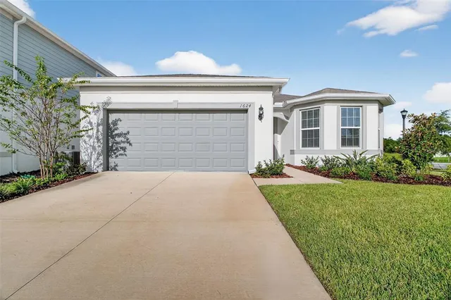 a front view of a house with a yard and garage