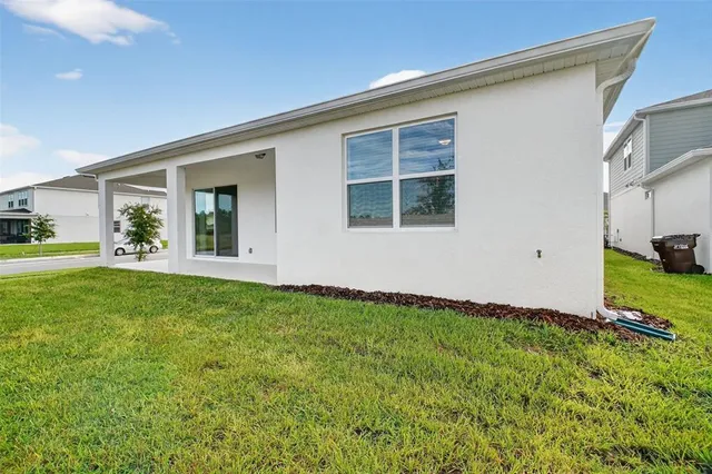 a view of an house with backyard space and windows