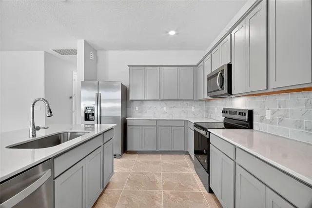 a kitchen with stainless steel appliances granite countertop a sink and cabinets