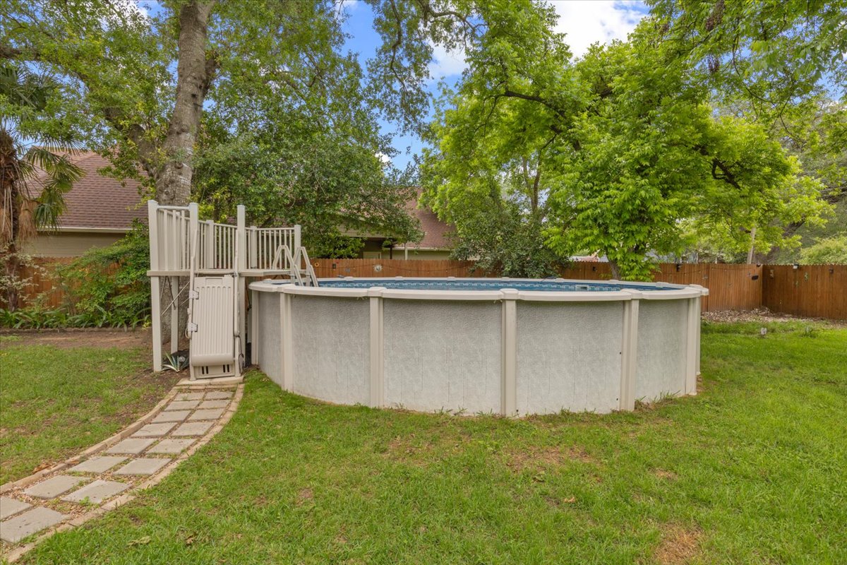 607 Short Street Smithville, TX 78957 - Photo 29 of 31 Expansive backyard featuring a large above-ground pool with an integrated deck and stairs