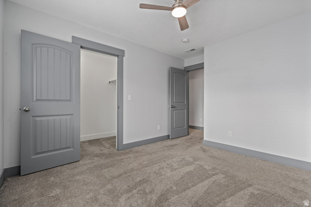 7822 North Copperbend Road Eagle Mountain, UT 84005 - Photo 28 of 46 Wall-to-wall carpeting, painted trim, and ceiling fan with integrated lighting