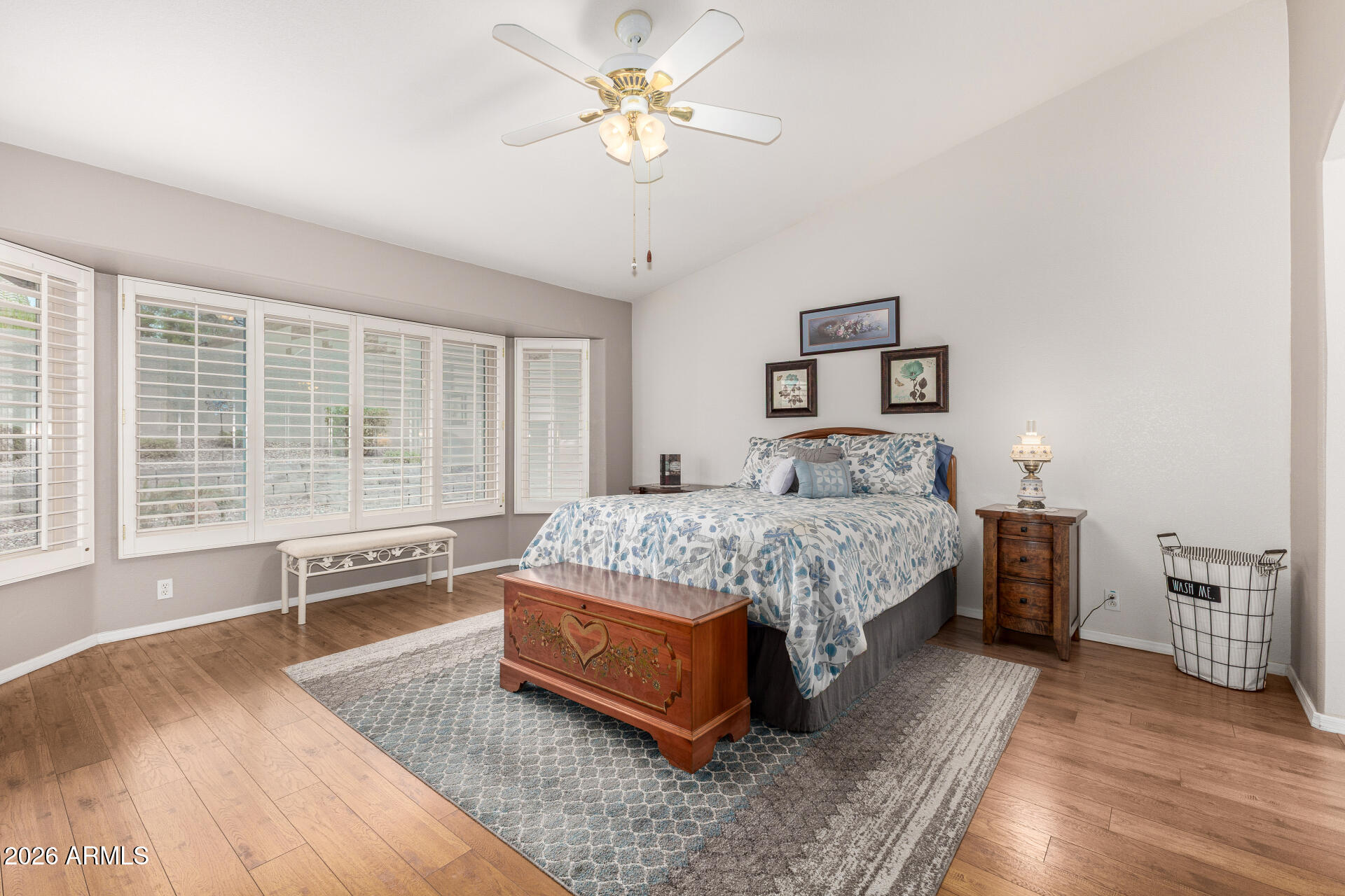 8302 West Marco Polo Road Peoria, AZ 85382 - Photo 15 of 30 a spacious bedroom with a bed a couch and a large window with wooden floor