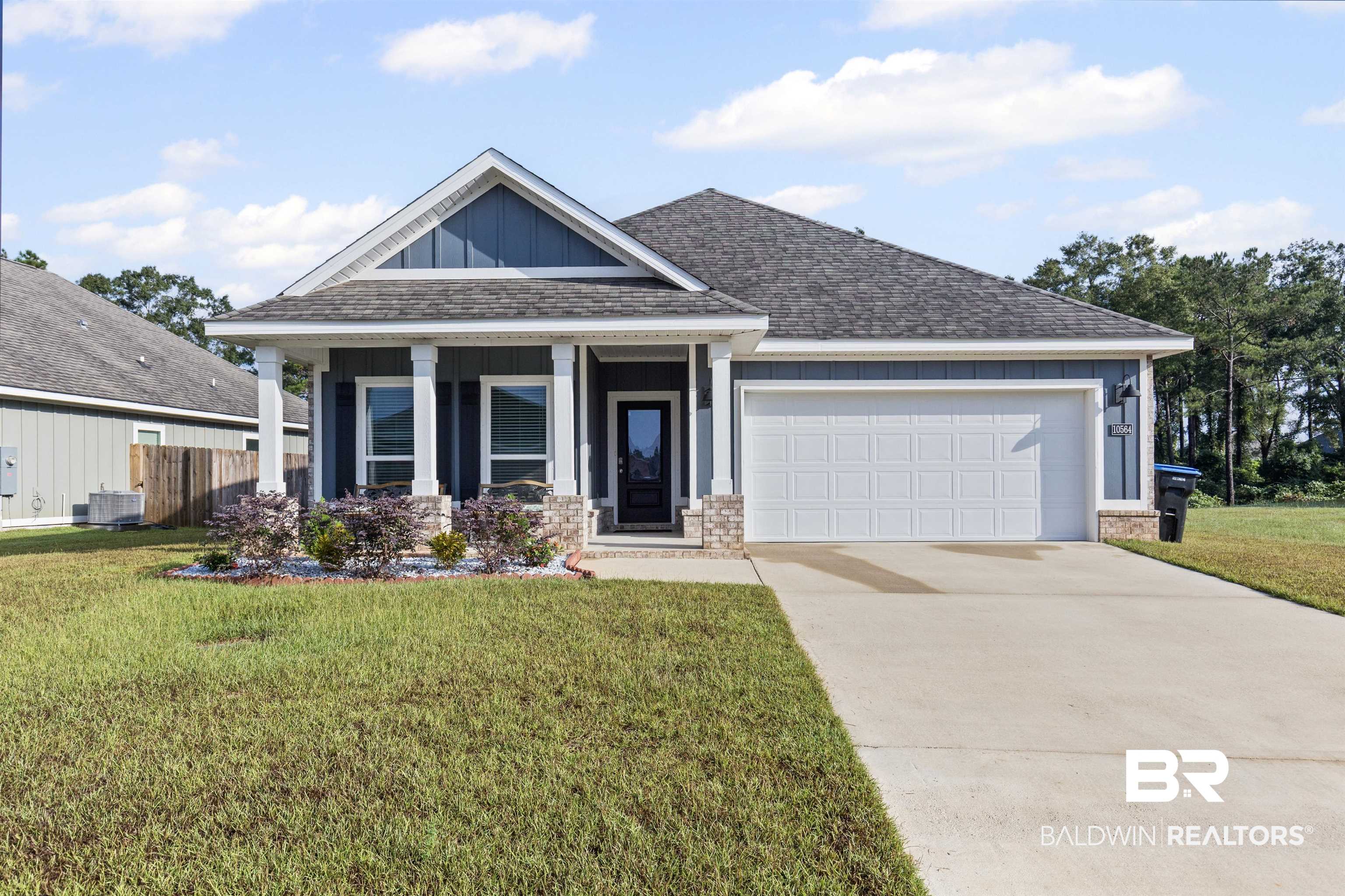 10564 Heirloom Road South Mobile, AL 36608 - Photo 2 of 24 Craftsman house featuring a shingled roof, board and batten siding, concrete driveway, and covered porch