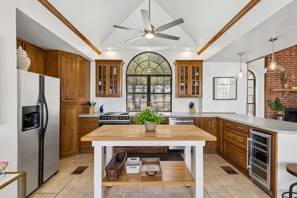 a large kitchen with stainless steel appliances a stove a refrigerator and a dining table