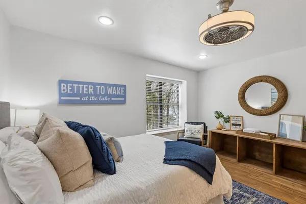 a bedroom with a bed a mirror and a large window