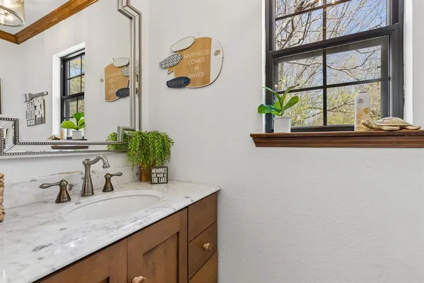 a bathroom with a granite countertop sink and a mirror