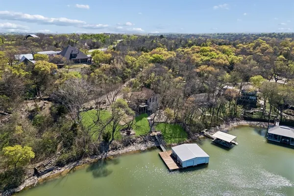 an aerial view of a house with a garden and lake view