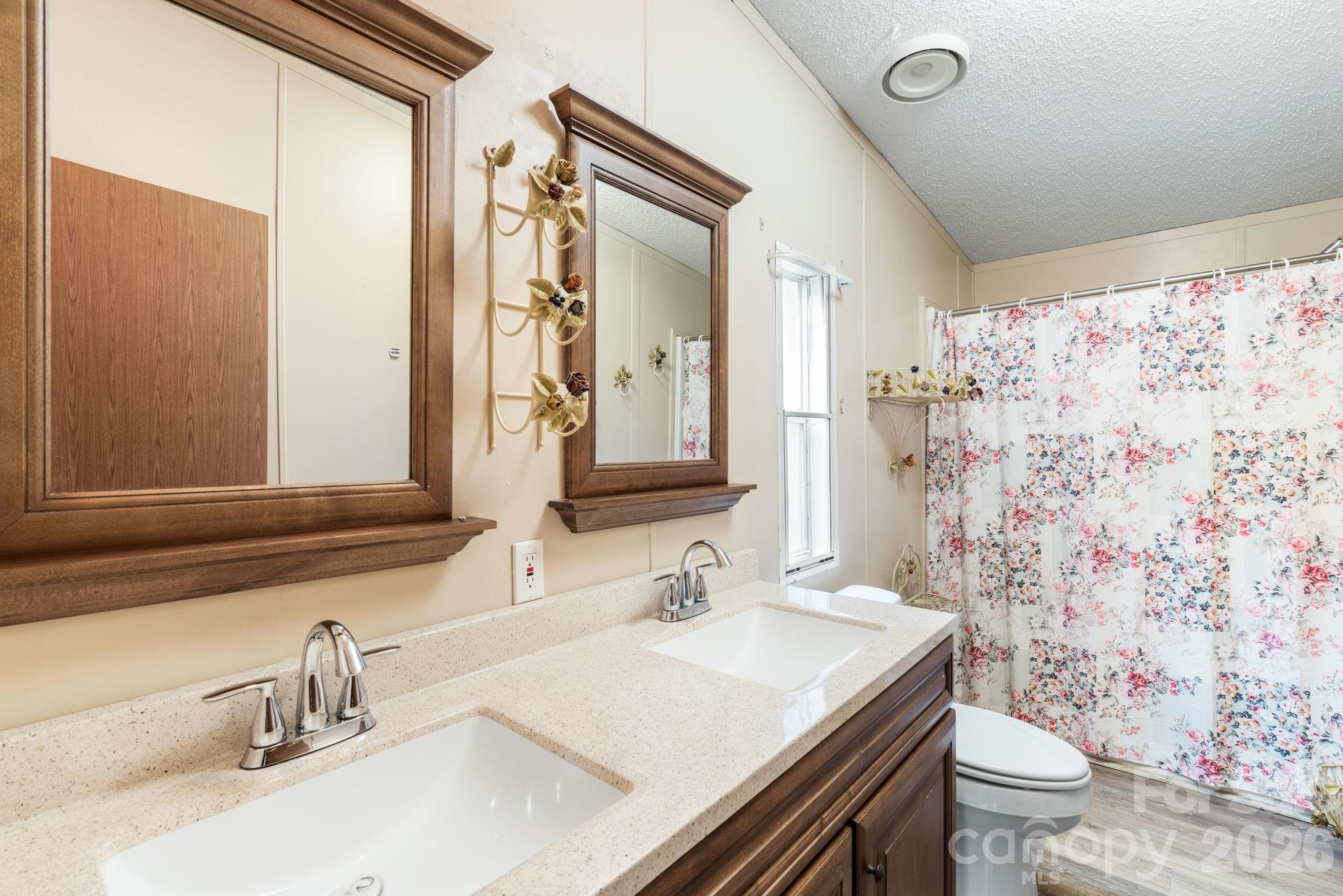 210 Ledbetter Lane Franklin, NC 28734 - Photo 25 of 32 a bathroom with a granite countertop sink a toilet and a mirror