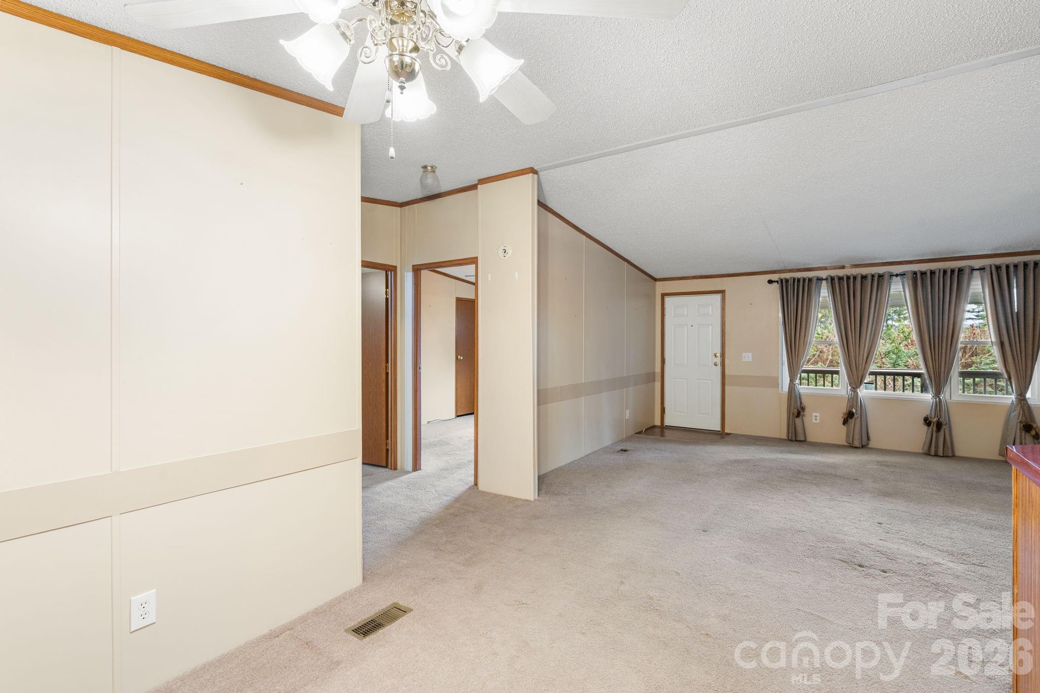 210 Ledbetter Lane Franklin, NC 28734 - Photo 28 of 32 an empty room with chandelier fan and windows