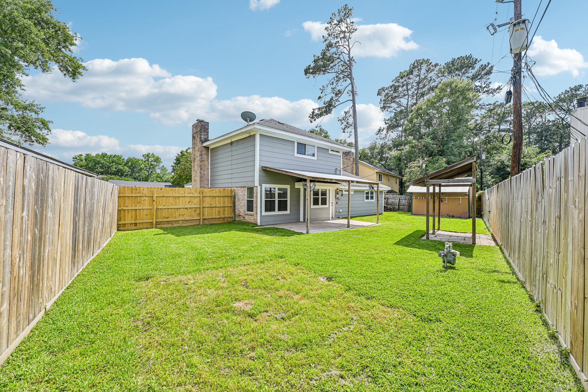 8 Arlington Street Conroe, TX 77301 - Photo 31 of 37 This photo highlights the spacious, fenced backyard with lush green grass.