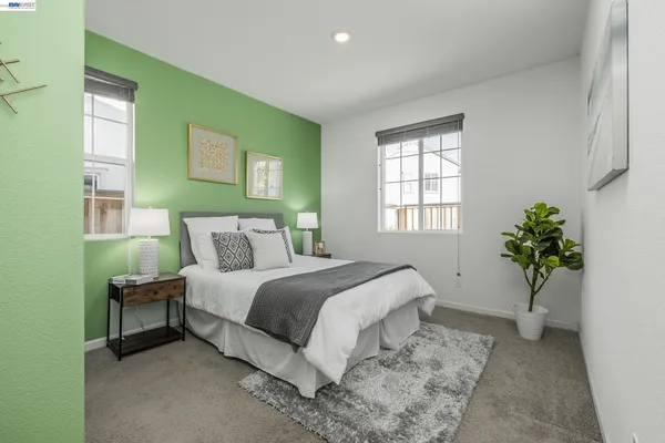 a bed sitting in a bedroom next to a window