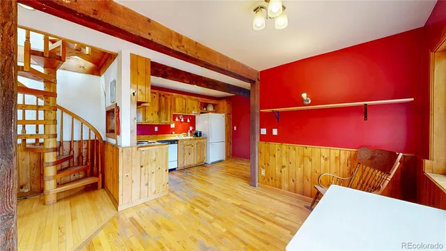 a view of a room with a large window and wooden floor