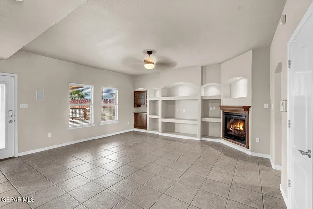 an empty room with fan and windows