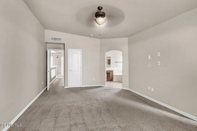 an empty room with a window and a fan