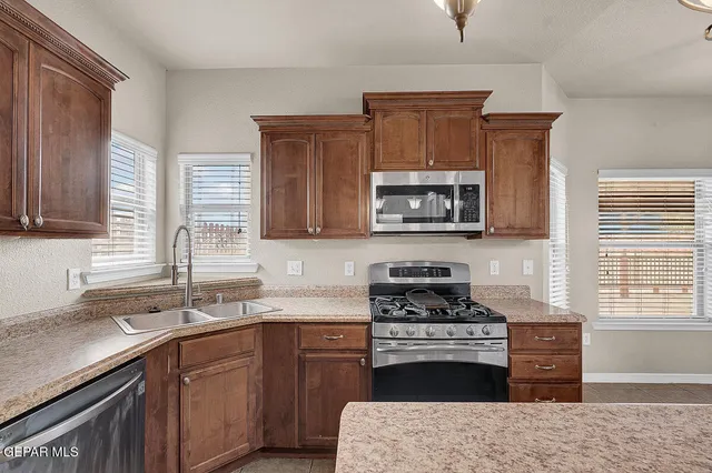 a kitchen with stainless steel appliances a sink stove and refrigerator
