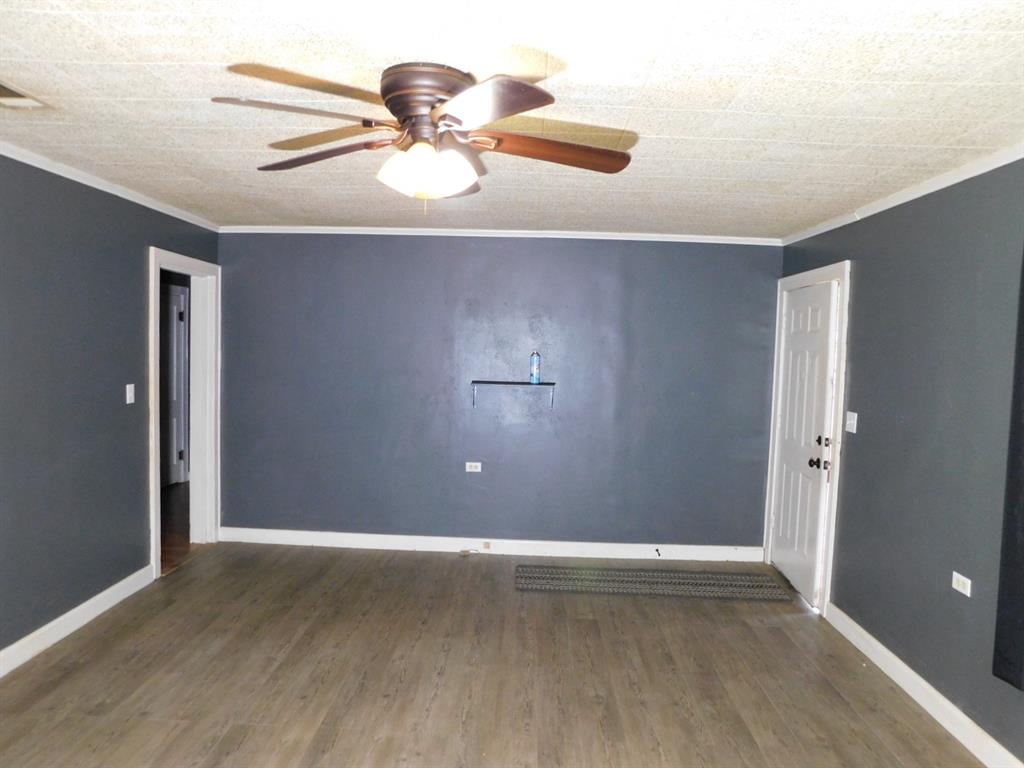 901 North Arkansas Street Springhill, LA 71075 - Photo 15 of 26 Spare room with baseboards, ornamental molding, wood finished floors, and ceiling fan