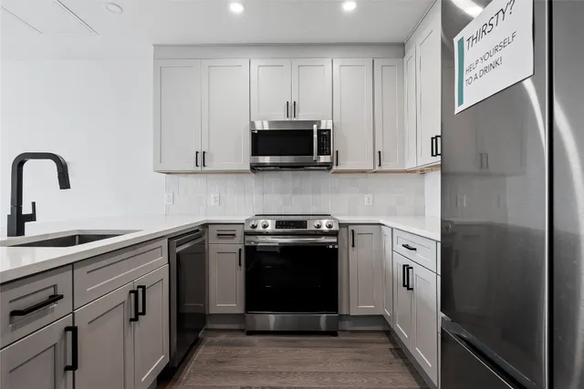 a kitchen with stainless steel appliances granite countertop a stove a sink and a refrigerator