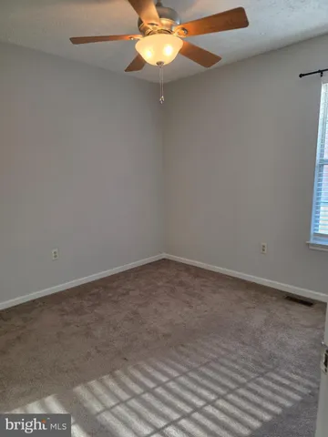 a view of a small space with wooden floor and a window